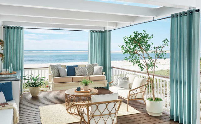 Outdoor patio with custom drapery and window treatments overlooking the beach
